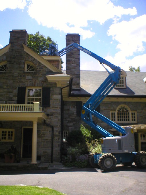 A Cherry Picker being used to repair & refurbish a stone chimney by W.S. Montgomery Chimney and Masonry Services in Ridley Park, PA 19078